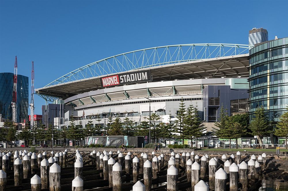 Marvel Stadium behind rows of old wharf piles