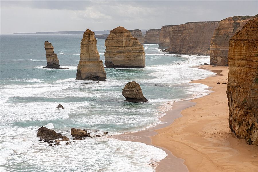 Limestone stacks of the Twelve Apostles rising from the sea beside tall cliffs