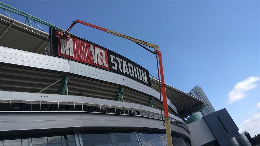 Workers installing the new Marvel Stadium sign on the stadium facade