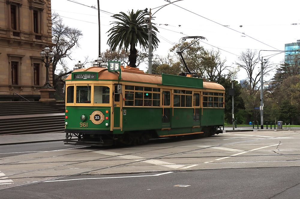 A green and gold W-class tram on the City Circle route