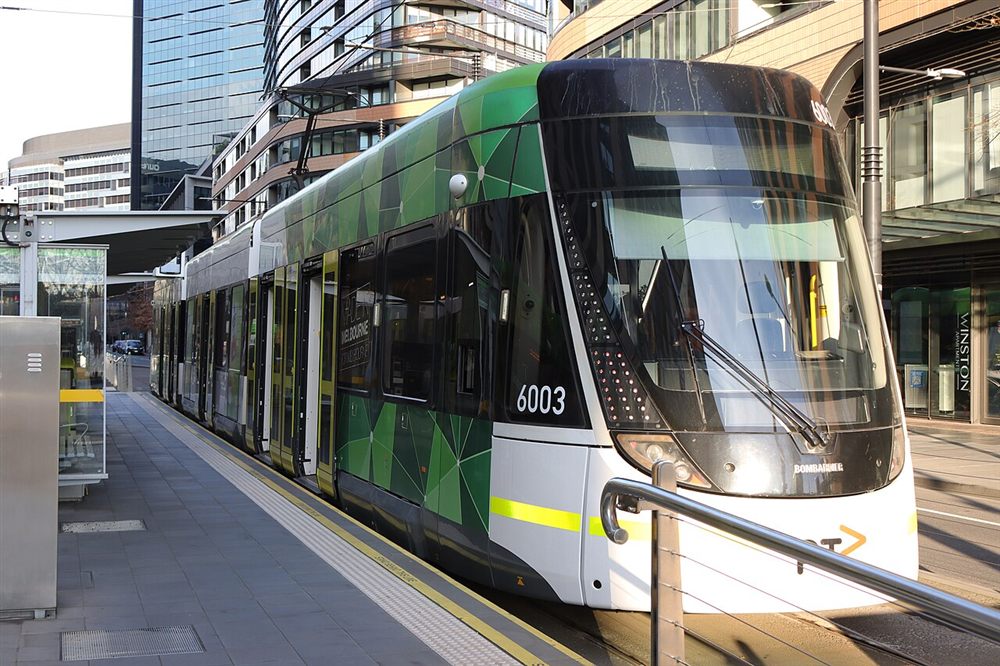 A modern E-class tram at the Victoria Harbour Docklands stop