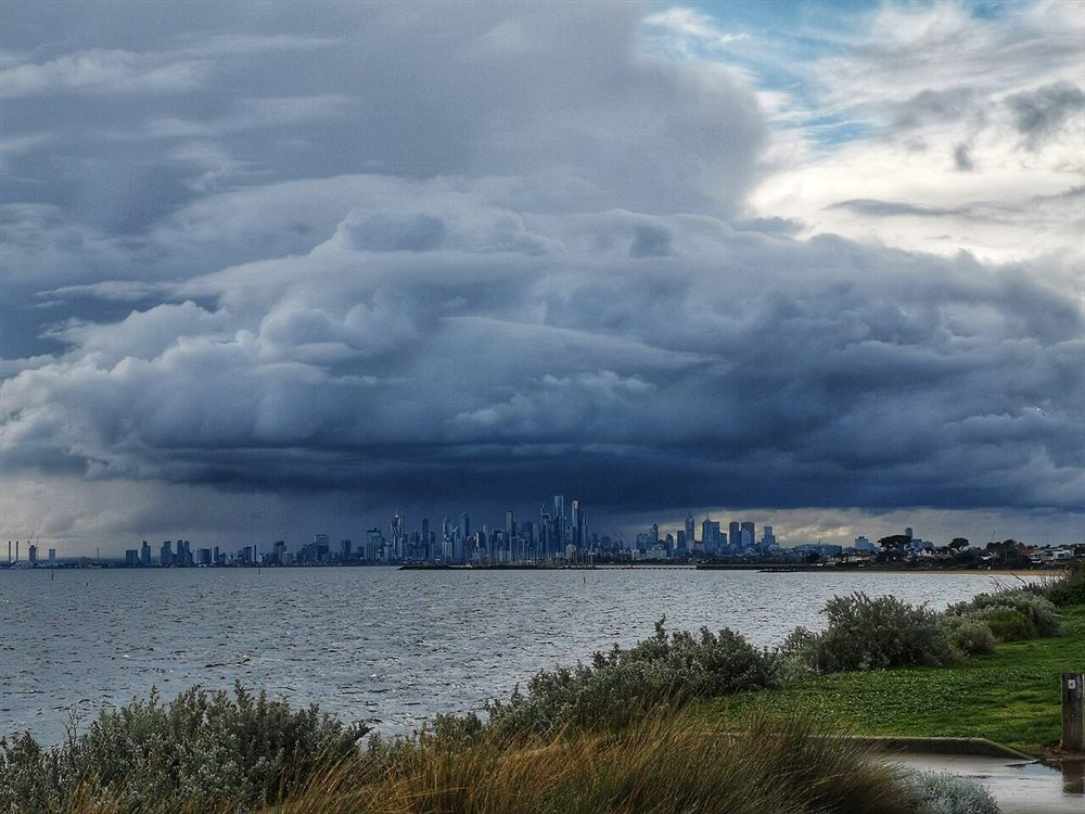 A dark storm front over the city skyline seen across the bay